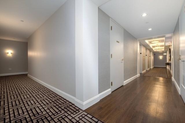 hallway with recessed lighting, wood finished floors, and baseboards