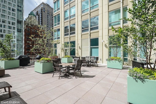 view of patio featuring a view of city, grilling area, and outdoor dining space