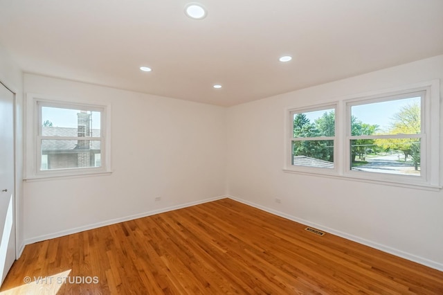 empty room featuring light wood-style flooring, a wealth of natural light, and recessed lighting