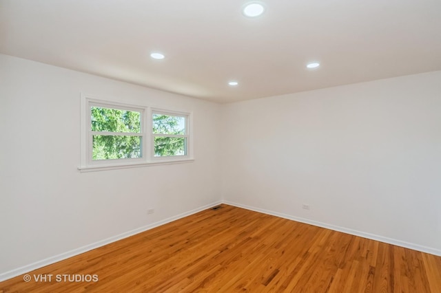 spare room featuring baseboards, light wood finished floors, visible vents, and recessed lighting