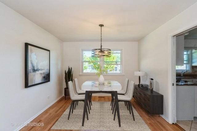 dining room featuring light wood-style flooring and baseboards