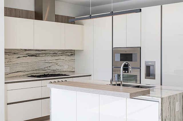 kitchen with white cabinetry, an island with sink, and modern cabinets