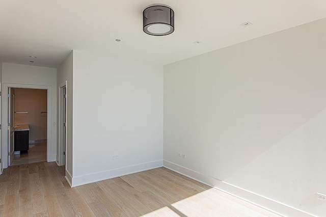 unfurnished room with light wood-style flooring and baseboards