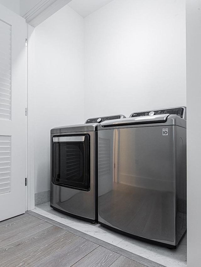 laundry room with laundry area, light wood-style floors, and washer and dryer