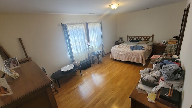 bedroom with light wood-type flooring and visible vents