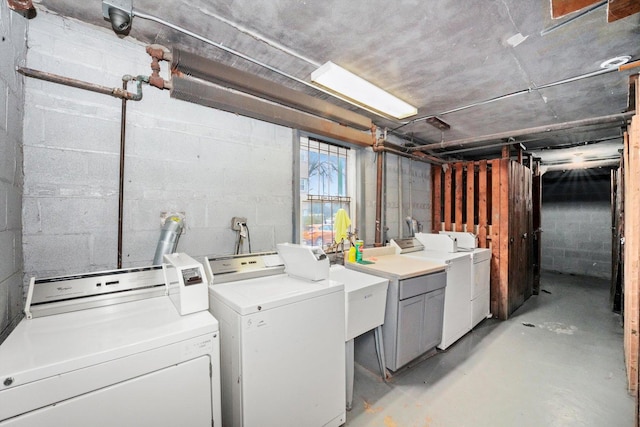 laundry area featuring concrete block wall, laundry area, and washing machine and clothes dryer