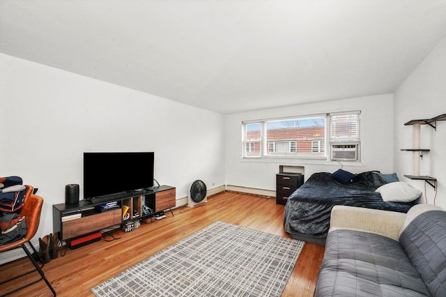 living room with cooling unit, baseboards, baseboard heating, and wood finished floors