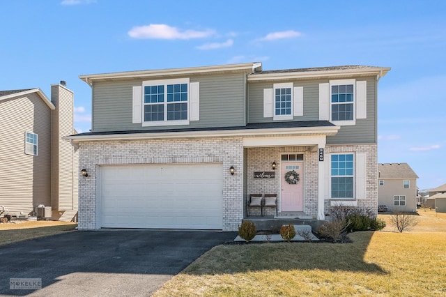 view of front of house featuring aphalt driveway, an attached garage, brick siding, and a front yard