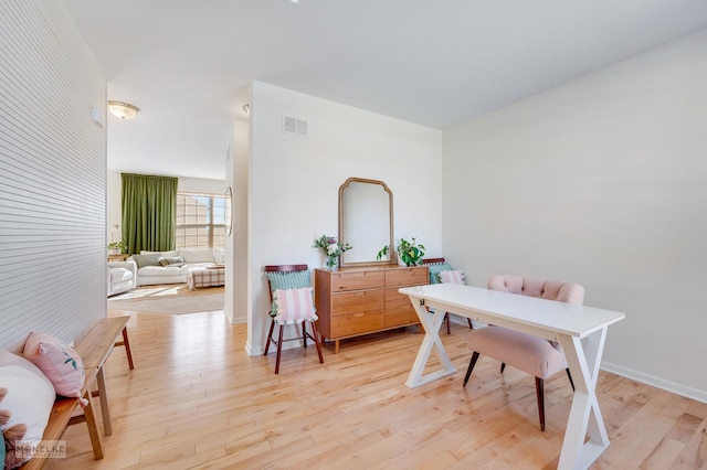 office space featuring light wood-style flooring, visible vents, and baseboards