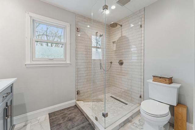 bathroom featuring a stall shower, baseboards, toilet, vanity, and marble finish floor
