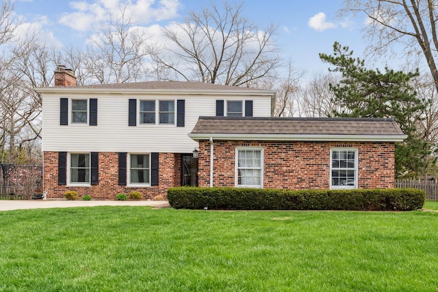view of front of property with brick siding, a front yard, and a chimney