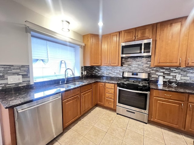 kitchen featuring appliances with stainless steel finishes, brown cabinetry, a sink, and backsplash