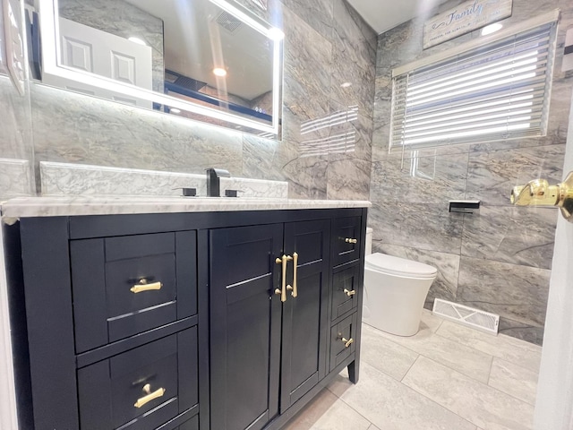 bathroom with toilet, visible vents, tile walls, and vanity