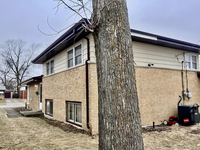 view of side of property with brick siding and central AC unit