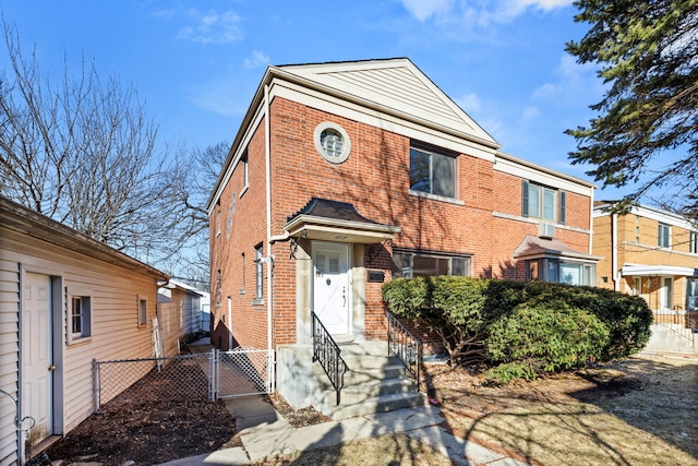 townhome / multi-family property featuring a gate, brick siding, and fence