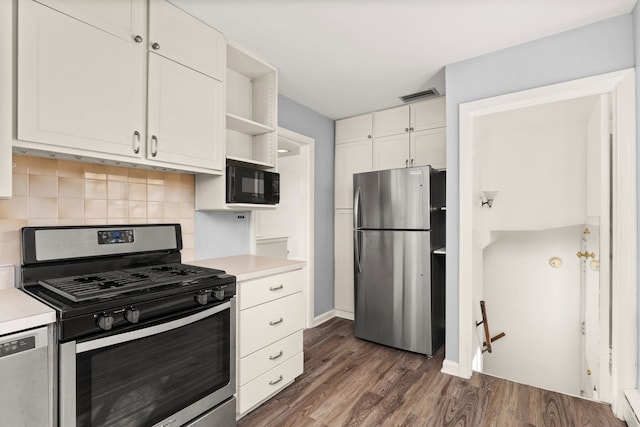 kitchen featuring stainless steel appliances, visible vents, light countertops, tasteful backsplash, and dark wood finished floors