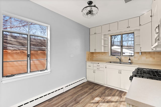 kitchen featuring decorative backsplash, a sink, baseboard heating, and open shelves