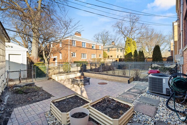 view of patio with an outdoor fire pit, central AC, fence, a garden, and a gate