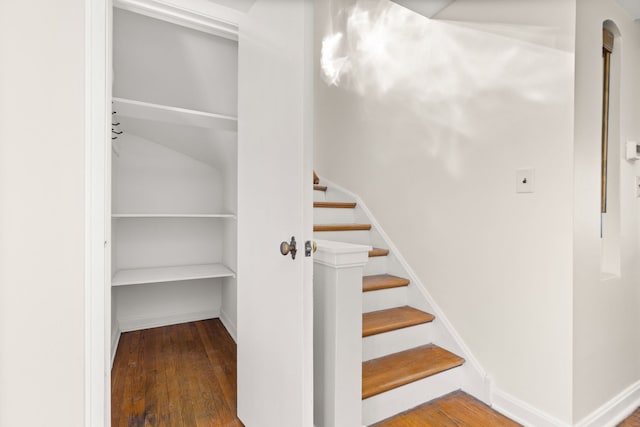 stairway featuring baseboards and wood finished floors