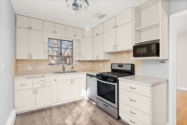 kitchen with light wood finished floors, open shelves, appliances with stainless steel finishes, and a sink