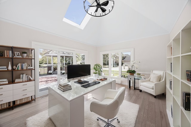 office area with lofted ceiling with skylight, ornamental molding, and light wood-style flooring