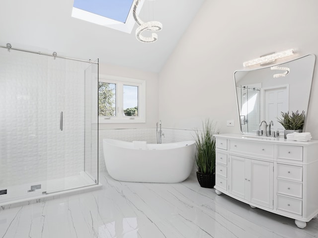 full bath with a skylight, a stall shower, marble finish floor, a freestanding bath, and vanity