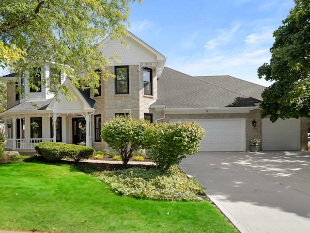 view of front facade with brick siding, a shingled roof, concrete driveway, an attached garage, and a front lawn