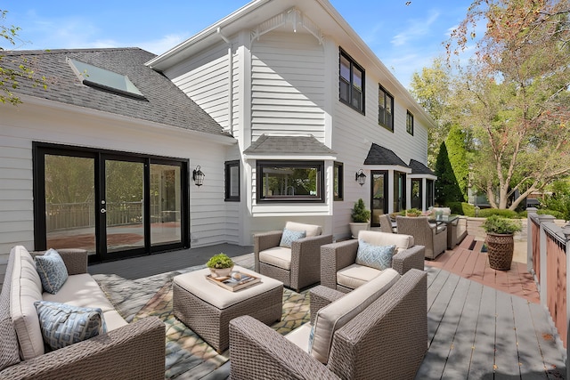 back of house featuring a shingled roof, an outdoor living space, and a deck