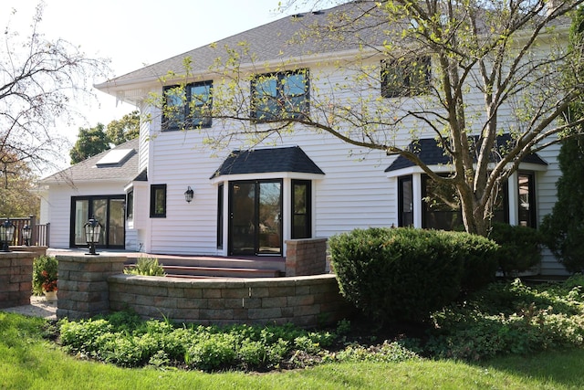 back of property featuring roof with shingles