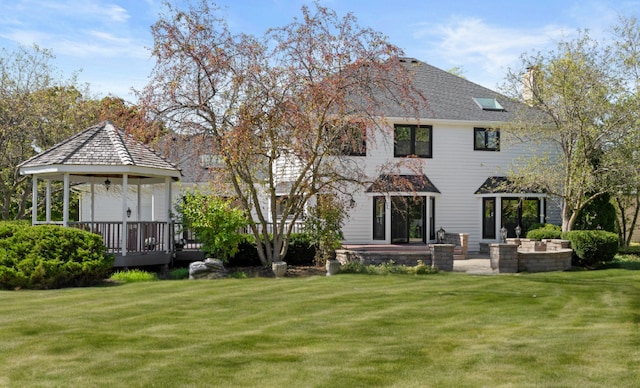 back of property with a yard and a gazebo