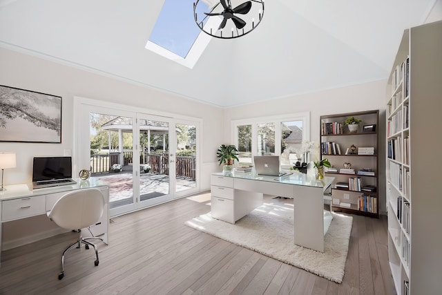 office space with lofted ceiling with skylight, a healthy amount of sunlight, crown molding, and hardwood / wood-style flooring