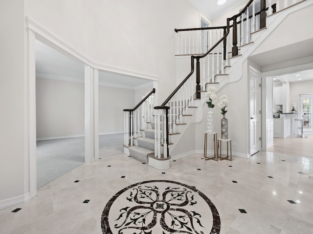 entrance foyer featuring crown molding, stairs, and baseboards