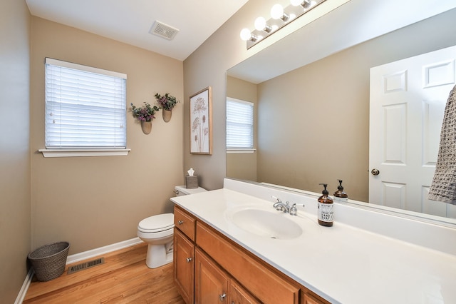 bathroom featuring visible vents, toilet, baseboards, and wood finished floors