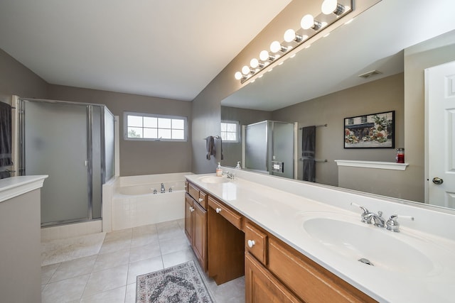 bathroom with tile patterned floors, a stall shower, a garden tub, and a sink