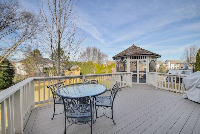 wooden deck with a gazebo, outdoor dining area, and area for grilling