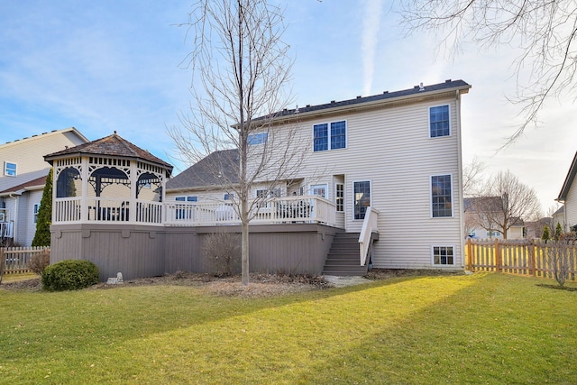 back of property with a gazebo, stairway, a yard, and fence