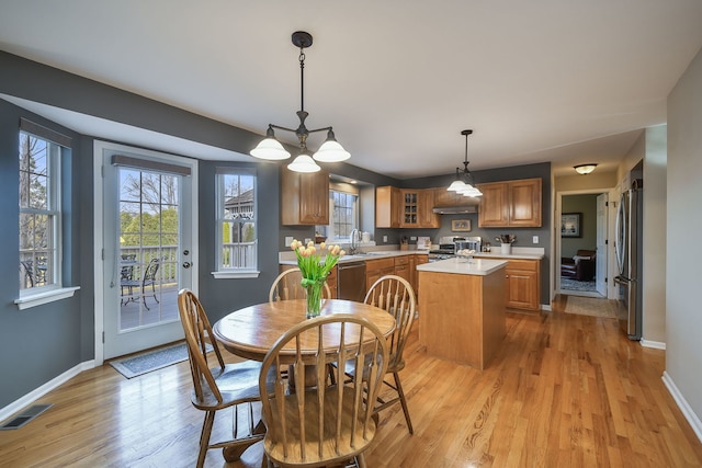 dining space featuring visible vents, light wood-style flooring, and baseboards