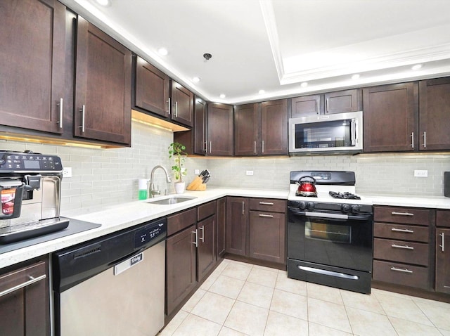 kitchen with backsplash, dark brown cabinetry, light countertops, appliances with stainless steel finishes, and a sink