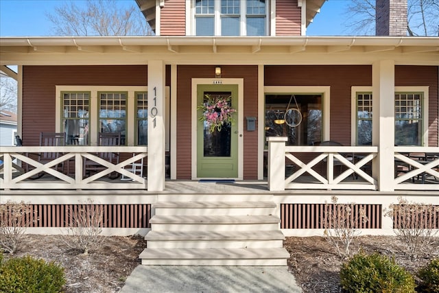 view of exterior entry featuring covered porch