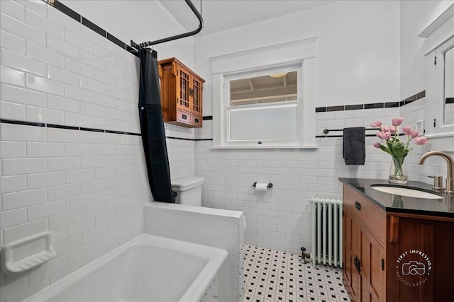 full bath featuring shower / bath combo with shower curtain, toilet, radiator, tile walls, and vanity