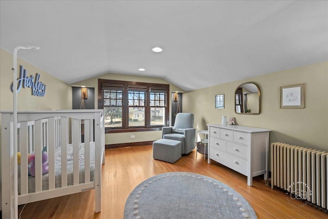 bedroom featuring light wood-type flooring, recessed lighting, baseboards, radiator, and lofted ceiling