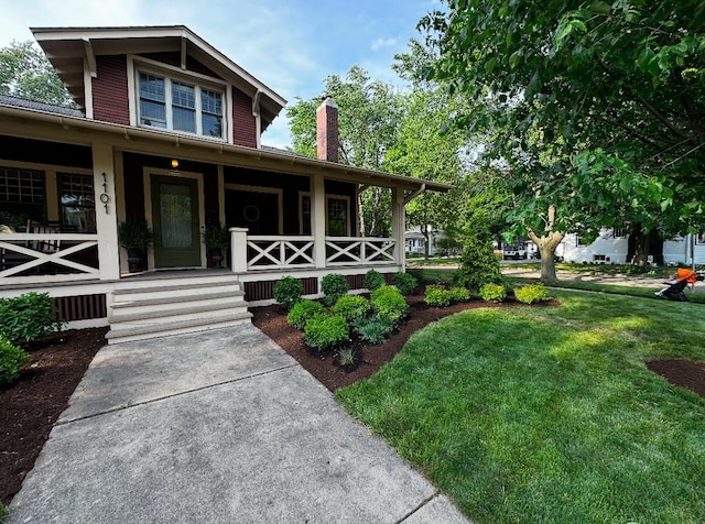 view of front facade with covered porch, a chimney, and a front lawn