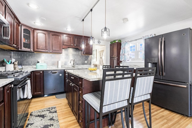 kitchen with black range with gas stovetop, light wood-style flooring, dishwasher, and fridge with ice dispenser