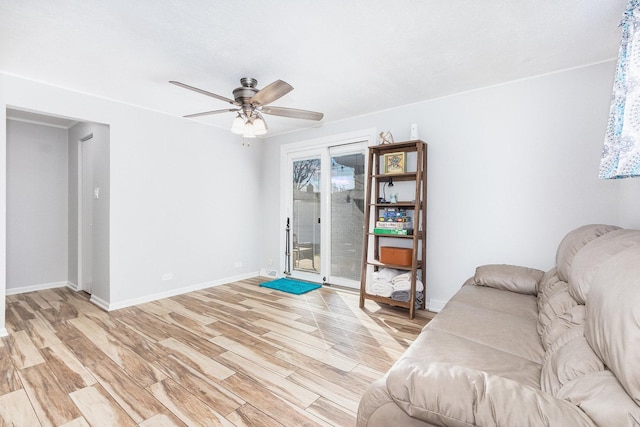 sitting room with ceiling fan, baseboards, and light wood-style floors