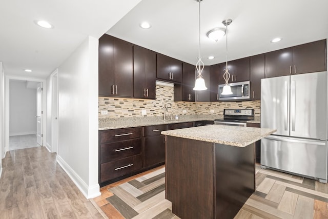 kitchen with stainless steel appliances, a sink, dark brown cabinetry, and decorative backsplash