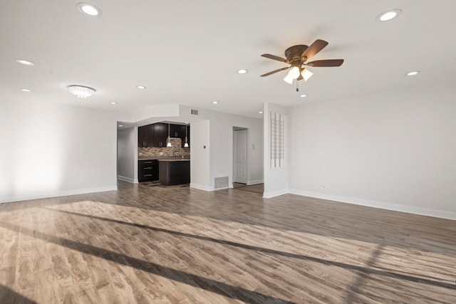 unfurnished living room featuring recessed lighting, visible vents, baseboards, and wood finished floors