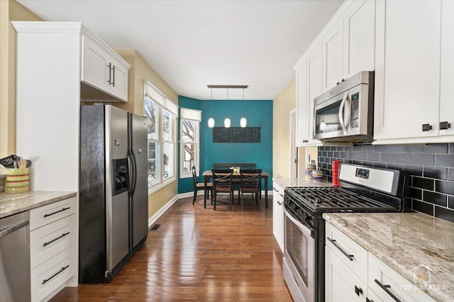 kitchen with dark wood finished floors, backsplash, white cabinetry, and stainless steel appliances