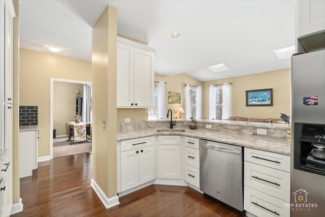 kitchen with a sink, dark wood finished floors, white cabinetry, stainless steel appliances, and light stone countertops