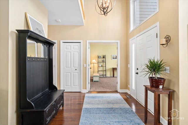 mudroom featuring a chandelier, baseboards, and dark wood-style flooring