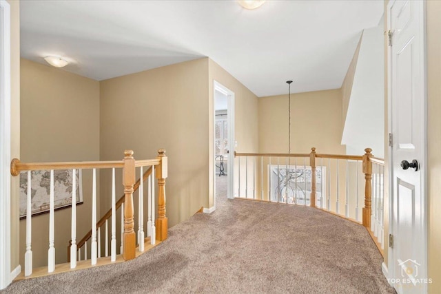 hall featuring an upstairs landing and carpet flooring